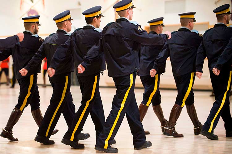 Cadets marching with navy pants with a yellow stripe.