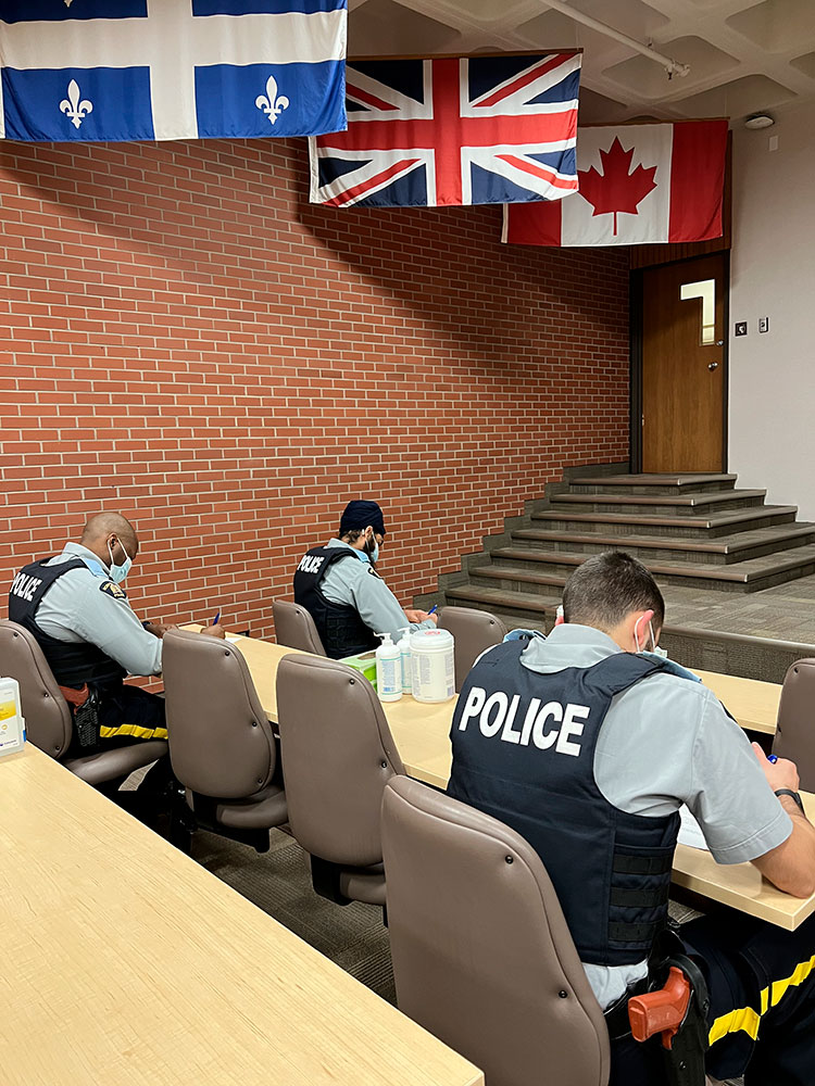 Cadets sit at desks writing an exam.