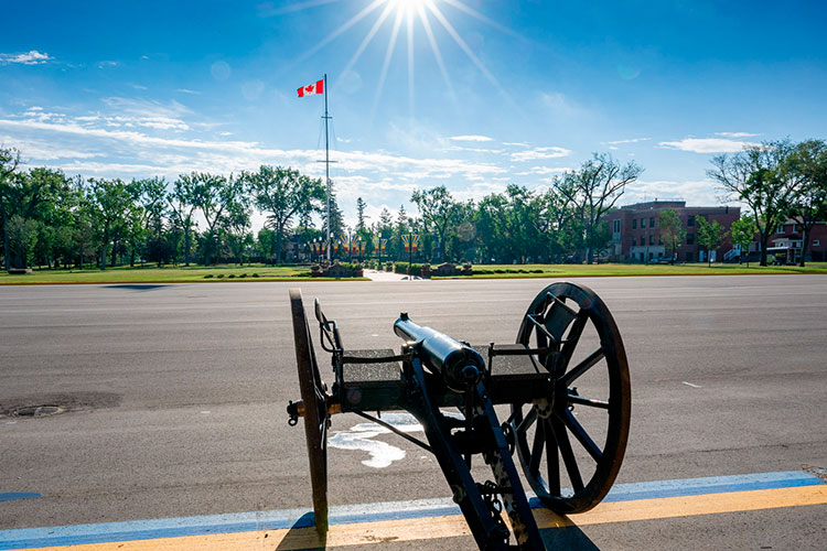 Parade Square at Depot on a sunny day. A historical field gun and Canadian flag can be seen.