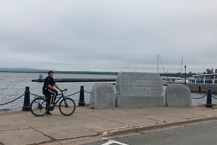 An RCMP member on a bicycle along the coast.