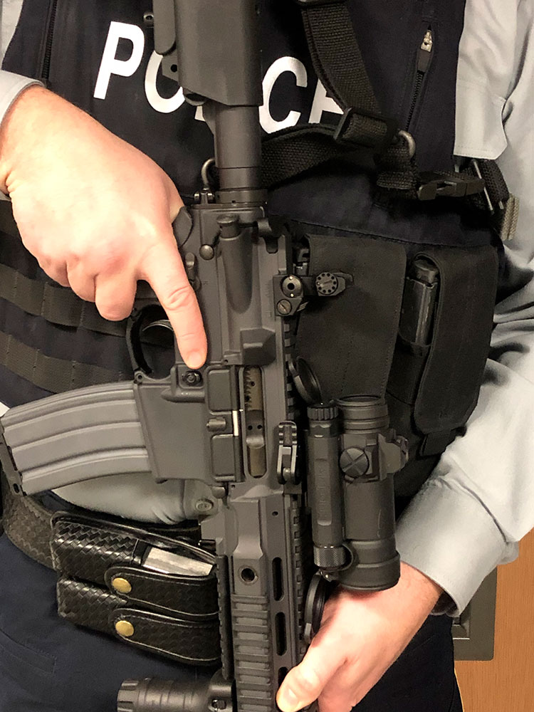 A close up of a cadet holding a patrol carbine with the barrel pointing down.