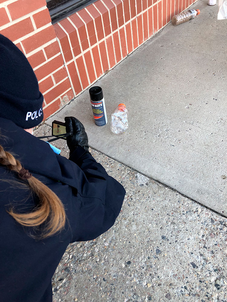 A cadet takes a photo of evidence during a training scenario.