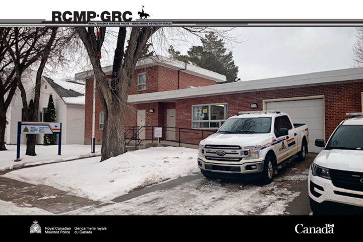 Canora RCMP Detachment building with snow outside and two vehicles parked in driveway