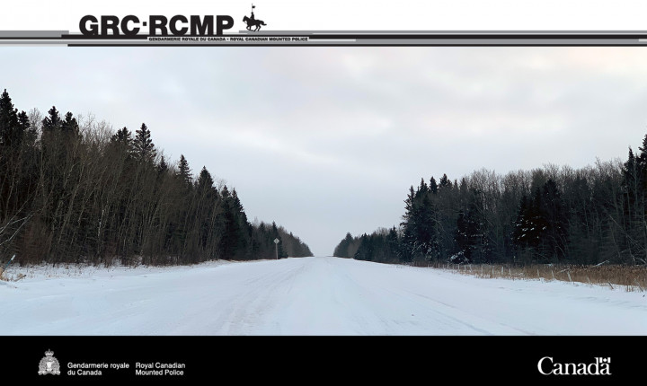 Route rurale de la Saskatchewan avec des arbres et de la forêt flanquant chaque côté des fossés remplis de neige.