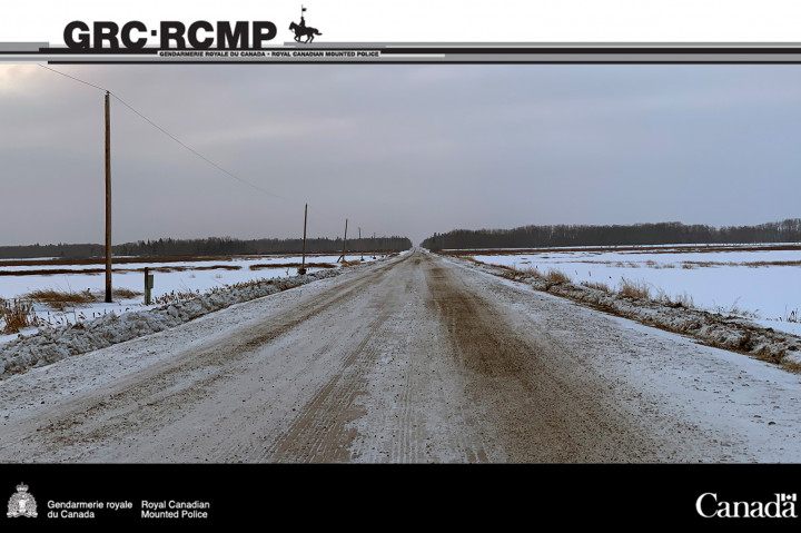 Route rurale de la Saskatchewan en hiver, avec des terres dégagées de chaque côté et de la neige dans les fossés.