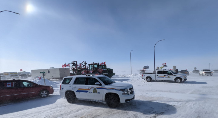 Photo of Tractors and RCMP vehicles on snowy highway