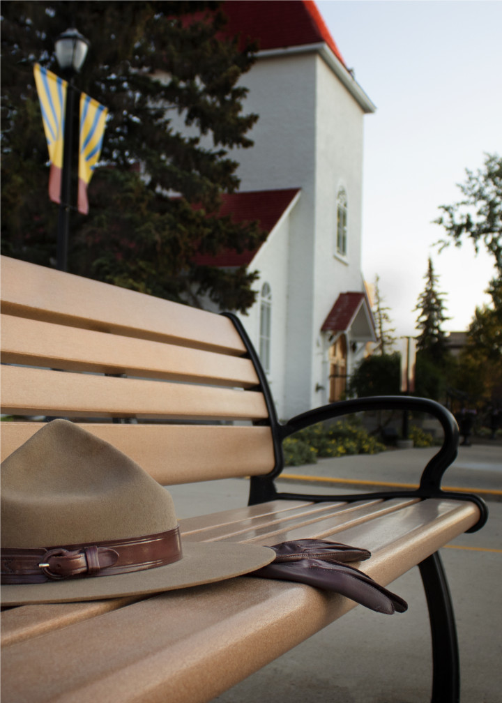 A Stetson hat and brown leather gloves rest on an empty bench.