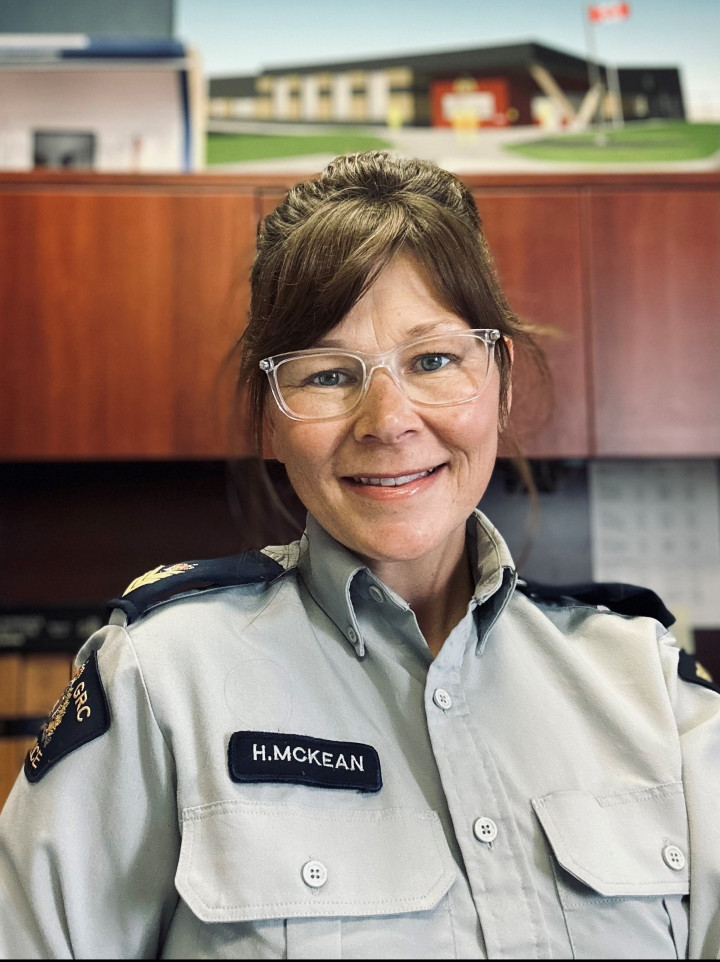 A uniformed female police officer wearing glasses is pictured smiling.