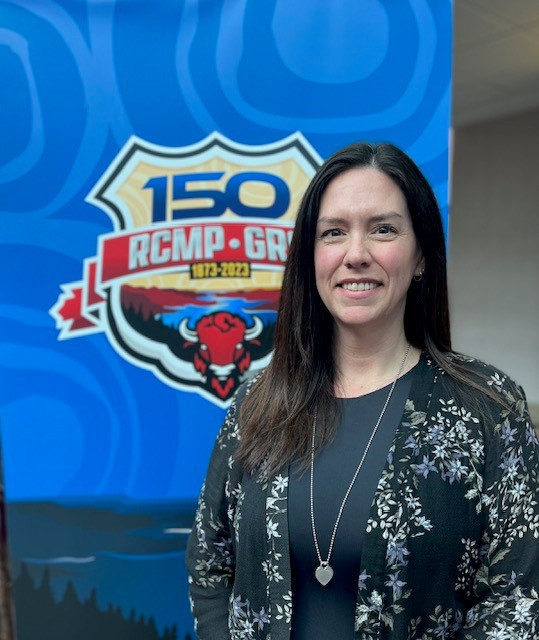 A photo of a smiling woman standing in front of blue signage with the RCMP 150 crest appears on a blue background with the RCMP logo.