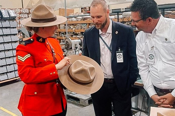 La caporale Marie-Michèle Ouimet, Mathews McGraw (GRC) et le maire de Garland (Texas), M. LeMay, inspectent un stetson de la GRC qui vient d'être fini.