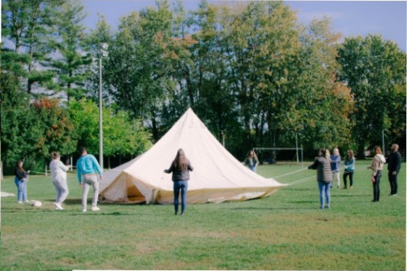 Plusieurs personnes montent la tente inuit.