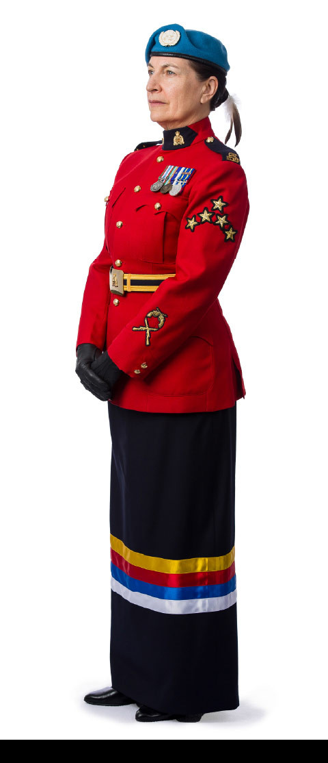 Le sergente Kelly Willis, membre de la Nation crie de Chisasibi, Québec, fondatrice du Réseau des femmes autochtones, porte un béret bleu des Nations Unies avec des plumes d'aigle attachées, la tunique rouge et une jupe à ruban