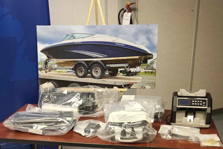 A picture of a boat is standing on an easel behind a table with plastic packages on it.