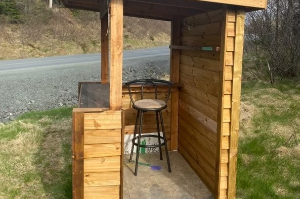 A side view of a wooden structure used as a small food canteen.