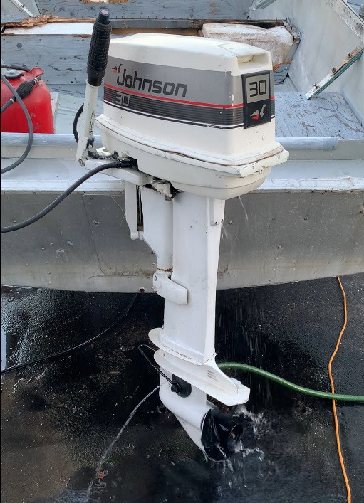 A white 30 hp Johnson outboard motor.