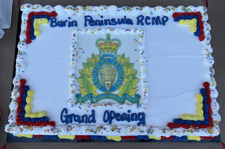 Un gâteau est représenté avec les mots « Burin Peninsula RCMP Grand Opening ».