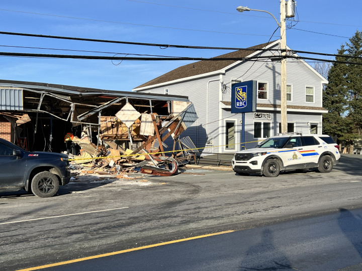 Photo du bâtiment détruit de la banque RCB. Une voiture de police se trouve à l'extérieur.